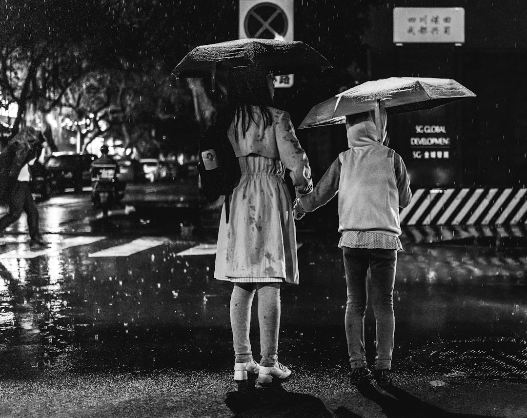 grayscale photo of 2 women standing on road