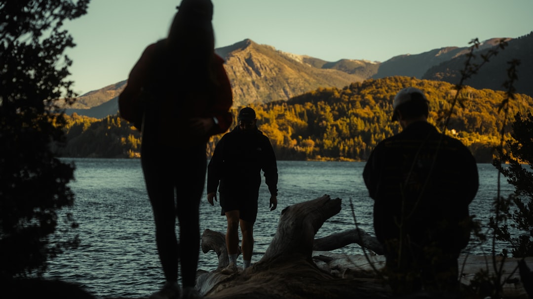 a group of people standing next to a body of water