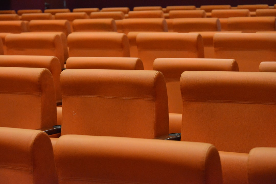 a row of orange seats in a theater