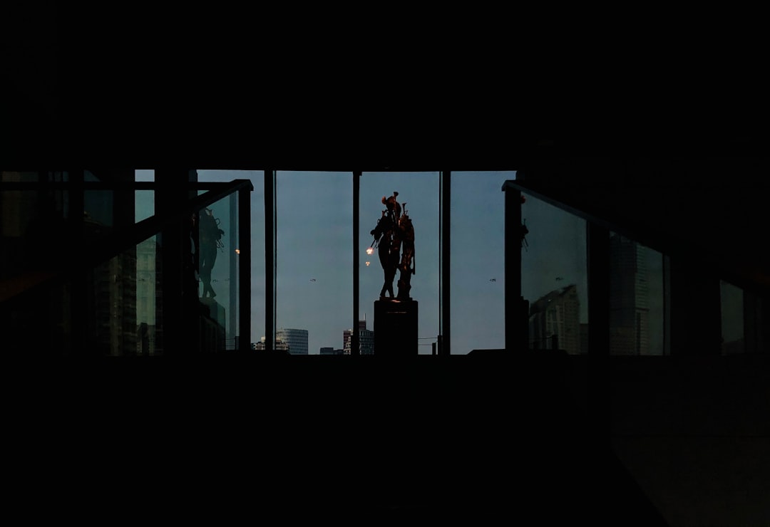 silhouette of woman standing on window during daytime